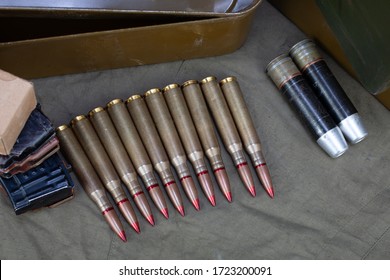 12.7?108mm Cartridges For A 12.7 Mm Heavy Machine Gun DShK Used By The Former Soviet Union With Another Ammunition On Green Background