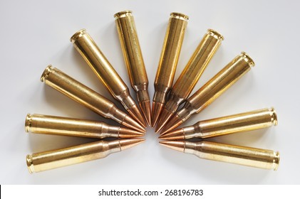 Cartridges with armor piercing bullets in a semi circle on a white background