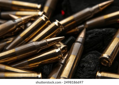 Cartridges for automatic carbine caliber .223 on charcoal. Ammunition for automatic and semi-automatic rifles. Dark background.