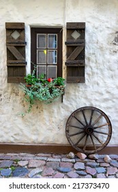 Cartwheel At The Window With Shutters And Flowers