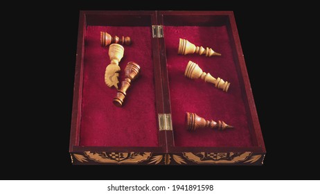 Carved Chess Pieces Are Put Away In A Box Made Of Wood With Red Cloth, Timelapse. Handmade Chess Set On A Black Background