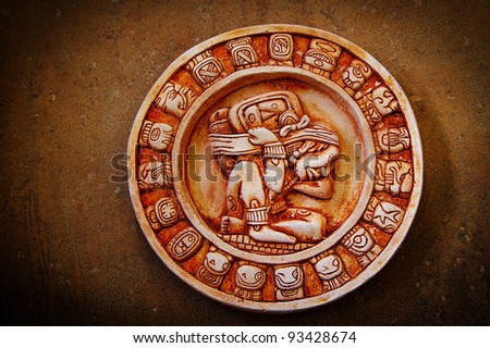 A carved Mayan calendar on textured background