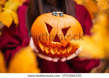 Jack-o’-lantern carved pumpkin. Halloween pumpkin with ghoulish face. Autumn colors.