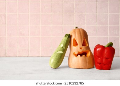 Carved pumpkin, zucchini and bell pepper for Halloween on table near pink tile wall - Powered by Shutterstock