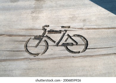 Carved Wooden Bike Sign On An Outdoor Bike Rack. Simple Bike Icon Outline.          