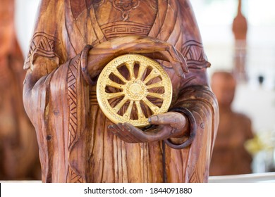 Carved wooden buddha hand Holding Dharmachakra.
Dhamma wheel of life, religion concept. 