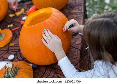 Carving big orange pumpkins for Halloween in late Autumn.