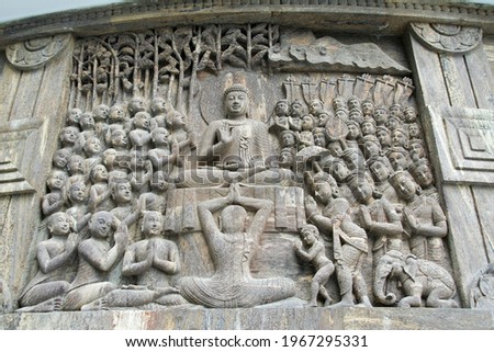 The carving of  Buddha delivering sermon while humble devotees listen attentively in a stupa in Darjeeling, India, Asia