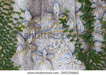 Carving of Stone Flowers on Ivy Covered Cemetery Headstone; Summerville, South Carolina.