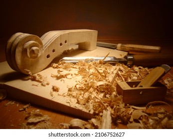 carving violin scroll from flame maple wood - Powered by Shutterstock