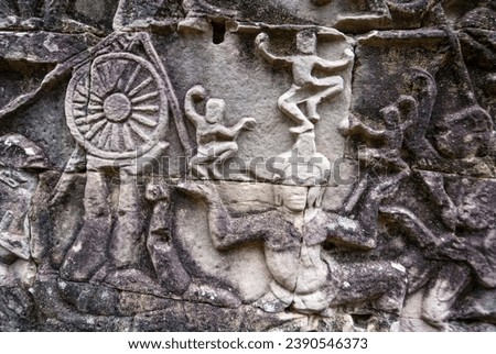 carvings of a circus act with dwarfs and a spinning wheel on the facade of Bayon temple, Angkor Thom, Angkor, Cambodia, Asia