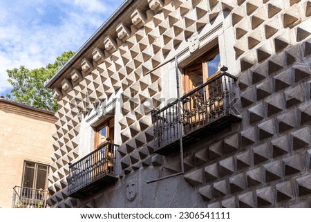 The Casa de los Picos, historic Renaissance building in Segovia, Spain, with characteristic facade of granite blocks carved into pyramid-shaped reliefs and balconies with heraldry of de la Hoz family.