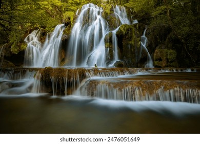 Cascade des Tufs Waterfall in France, located in the Jura region, known for its unique tufa formations and serene, lush surroundings. - Powered by Shutterstock