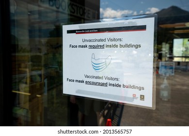 Cascade Locks, OR, USA - July 21, 2021: The Mask Policy Sign At The Entrance To Bonneville Lock And Dam Visitor Center Says Mask Is Required For The Unvaccinated While Encouraged For The Vaccinated.