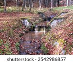 The cascading stream in the park in Bardejov spa retains water in nature.