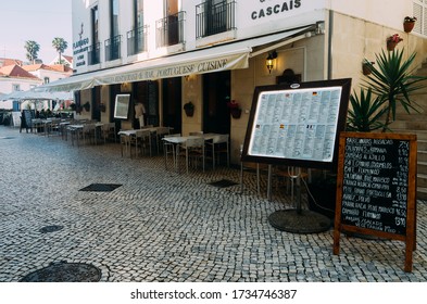 Cascais, Portugal - May 18, 2020: Waiter Wearing Face Mask Outside An Empty Restaurant Patio During The Descalation Of Lockdown Phase During The Coronavirus Covid-19 Oubreak