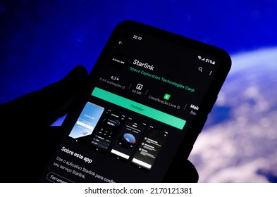 Cascavel, Parana, Brazil - June, 2022: Person installing Starlink app on smartphone via Google Play, internet via satellite. In portuguese language
