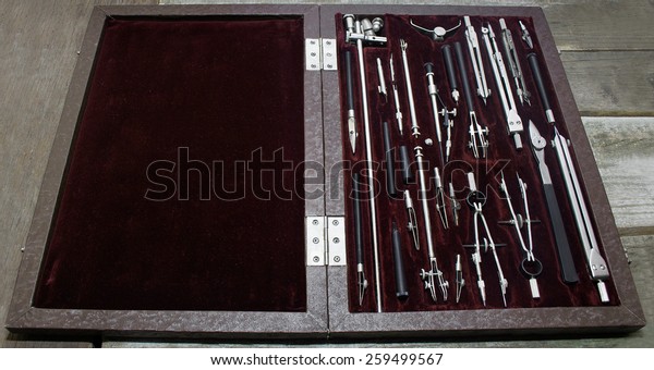 Case of drawing instruments. Old\
Case of drawing instruments laying on a wooden grunge\
table.