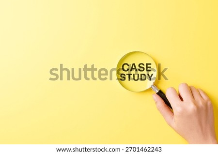 Case study research concept, hand holding magnifying glass focusing on bold text CASE STUDY over yellow background symbolizing detailed investigation, learning method and business or academic analysis