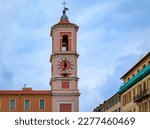 The Caserne Rusca clock tower with restaurants and shops in front of it in the streets of the Old Town, Vieille Ville of Nice France