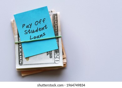 Cash Dollars Money With Blue Note Written Pay Off Student Loans , Concept Of Financial Management Strategy .set Aside Amount Money To Pay More Than Minimum , Extra Payment To Help Pay Off Faster