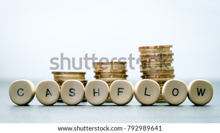 CASH FLOW letter block and stack coins, business concept.
