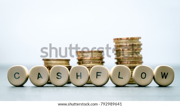 CASH\
FLOW letter block and stack coins, business\
concept.