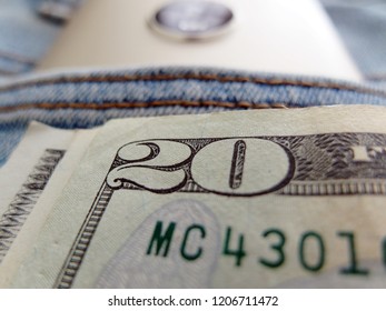 Cash money and smart phone in blue jeans pocket -concept of young small online business owner in a social media technology wireless internet world.