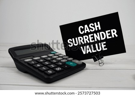 Cash Surrender Value text message on sticky note with calculator on wooden background