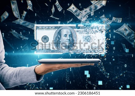 Cash and traditional money disappearance, money digitalization and inflation concept with vanishing 100 dollar banknote above human hand with digital tablet on dark background under dollar rain