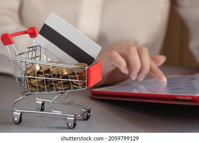 cashback concept, money and bank card in the basket, shopping in the online store, payment by credit card, internet banking, personal account, focus on coins