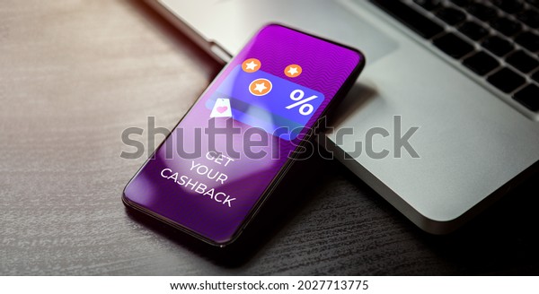 Cashback
customer loyalty program concept. Smartphone with discount card
with rewarding marketing points on the screen and text - get your
cashback. Rewards and money refund
service.