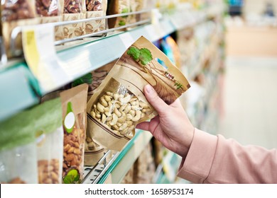 Cashew nuts in hand in the store - Powered by Shutterstock