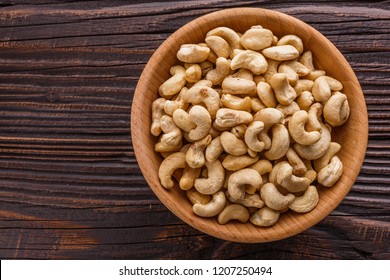 cashew nuts on a rustic wooden background - Shutterstock ID 1207250494