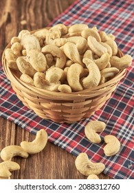 Cashews in a basket on a napkin. Wooden table with nuts.                               