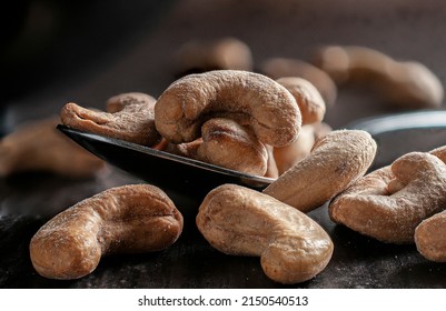 Cashews On A Spoon And On A Wooden Table With A Black Bowl And Dark Wooden Wall In The Background Dark Food Or Moody Light Macro Photography