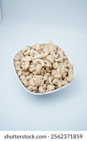 Cashews, raw cashews in a bowl. The shelled seeds of the cashew tree Anacardium occidentale. Used as a snack nut, and in recipes, or processed into cashew butter or cheese.