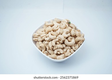 Cashews, raw cashews in a bowl. The shelled seeds of the cashew tree Anacardium occidentale. Used as a snack nut, and in recipes, or processed into cashew butter or cheese.