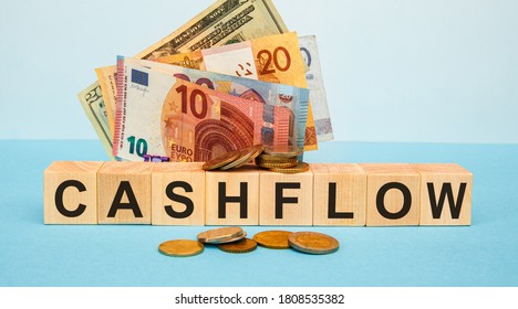 CASHFLOW - Word Written On Wood Cubes On The Background Of Various Banknotes. Financial Concept