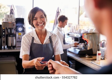 Cashier Accepts Card Payment From Customer In Delicatessen