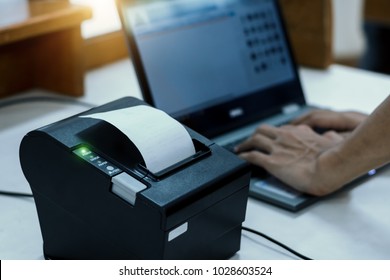 Cashier Are Recording Sales Data On Notebook With Thermal Receipt Printer At Counter Service.For Mockup And Advertising.The Concept Of Trading Business.Receipts And Invoices