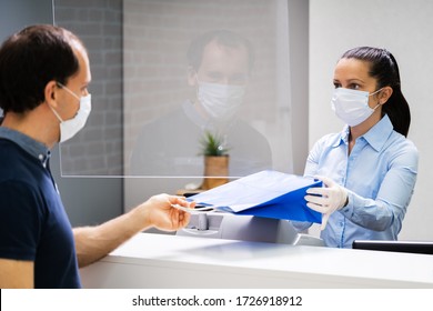 Cashier In Retail Shop Or Store At Counter Wearing Face Mask