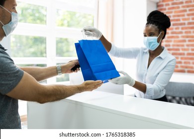 Cashier In Retail Shop Or Store At Counter Wearing Face Mask