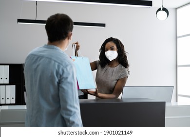 Cashier In Retail Shop Or Store At Counter Wearing Face Mask