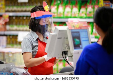 Cashier or supermarket staff in medical protective mask and face shield working at supermarket. covid-19 spreading outbreak  