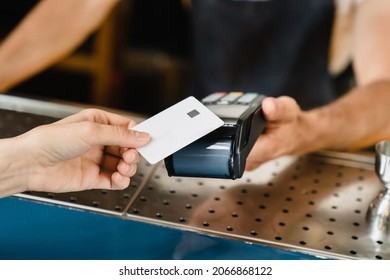 Cashless payment method. Closeup shot of micro ATMs while customer paying with credit card in bar restaurant cafe. E-commerce e-banking concept.