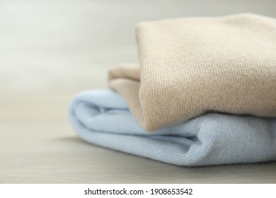 Cashmere clothes on wooden table, closeup view