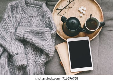 Cashmere Sweater, Reading And Serving Tray On Gray Sofa. Warm Weekend At Home. Detail Of Cozy Winter Interior. Watching Movies On Tablet Pc.