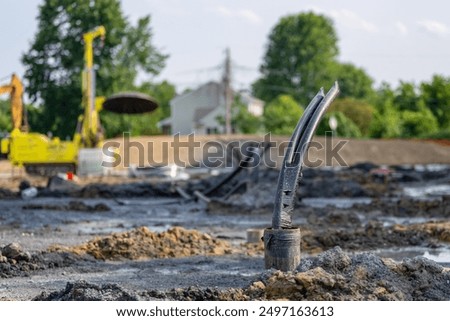 Casing pipe with polyethylene ground loop pipes in the process of being installed in a new geothermal well field.
