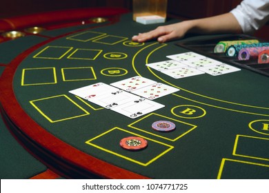 Casino Black Jack Table With Chips And Cards. Winning Combination. Hand Of Croupier Behind Gambling Table.